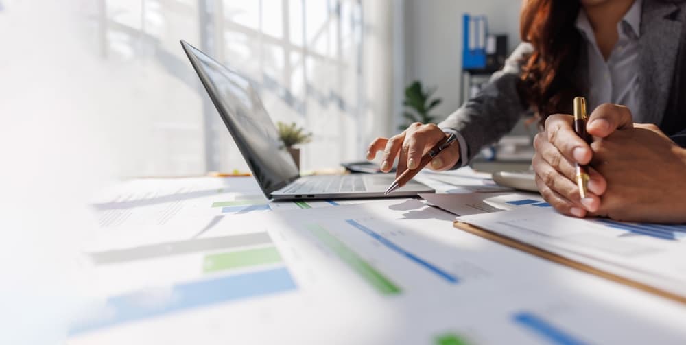 Profissionais analisando planilhas e gráficos durante o planejamento financeiro 2026 do negócio.