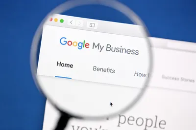 Tela do Google My Business ampliada por uma lupa sobre fundo azul, representando o perfil da empresa no Google