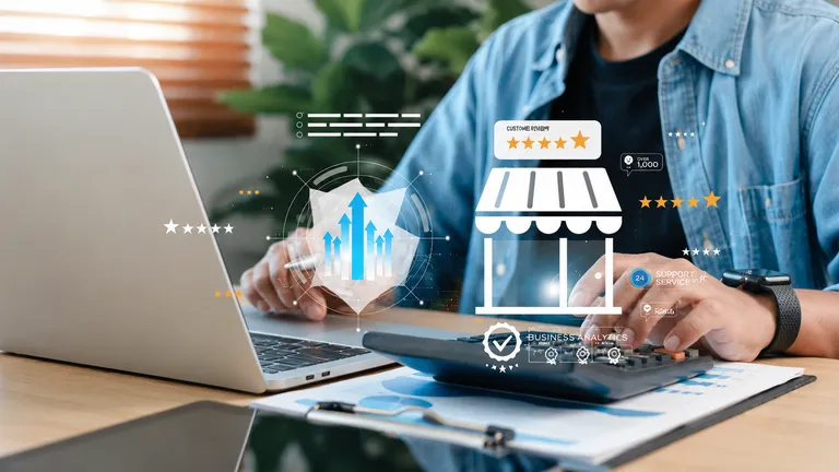 Empreendedor analisando as finanças do negócio com computador, calculadora e gráficos de crescimento financeiro