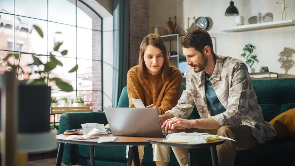 Casal analisando despesas e organizando o controle financeiro no notebook