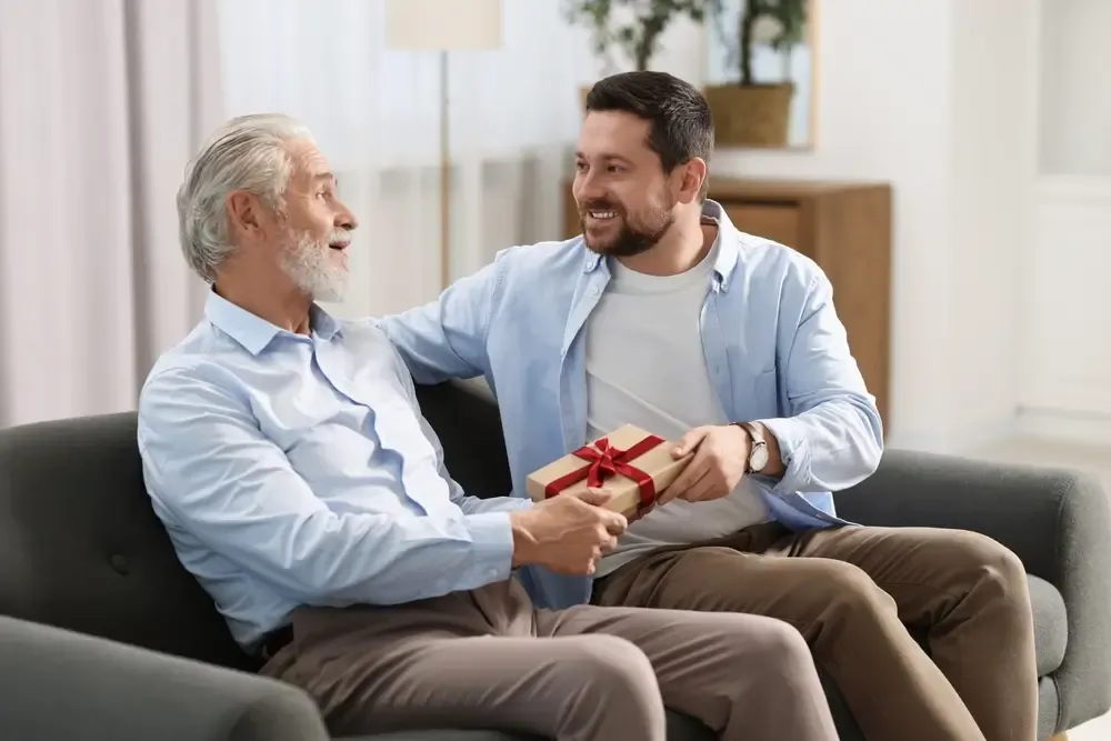 Momento de filho presenteando o pai com caixa de presente no Dia dos Pais