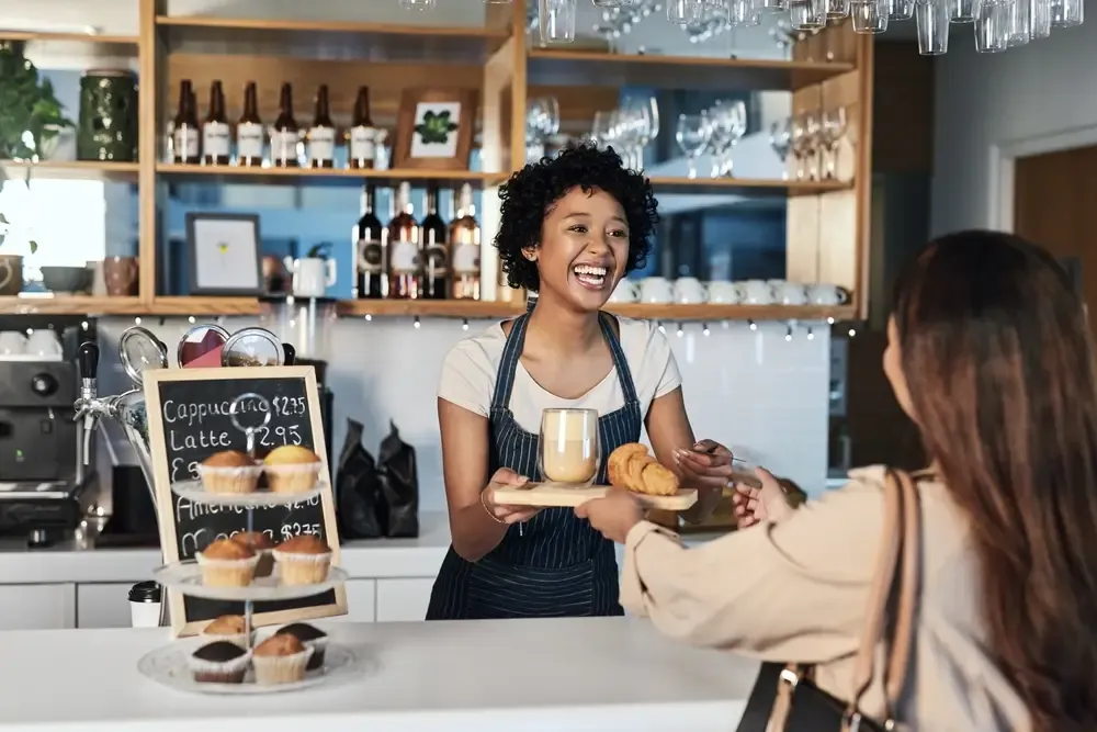 Funcionária servindo cliente com simpatia, exemplificando um pós-venda acolhedor.