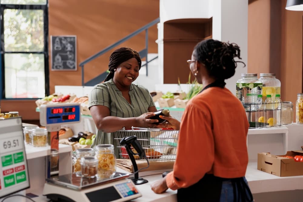 Cliente realizando compra em pequeno comércio durante campanha para aumentar as vendas no Mês do Consumidor
