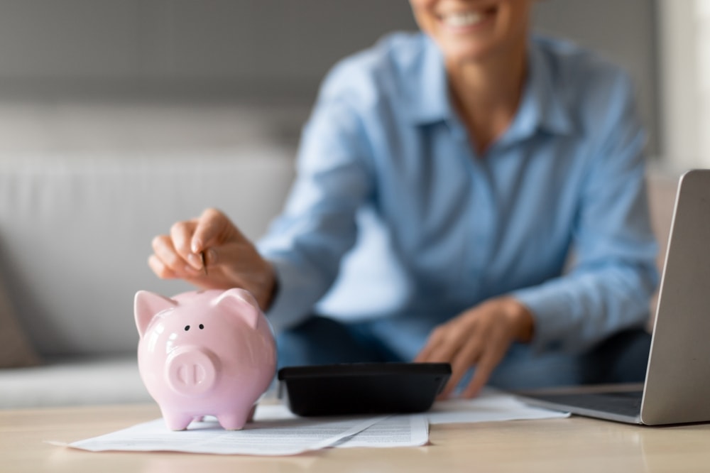 Pessoa guardando dinheiro em cofrinho como símbolo de boa gestão financeira