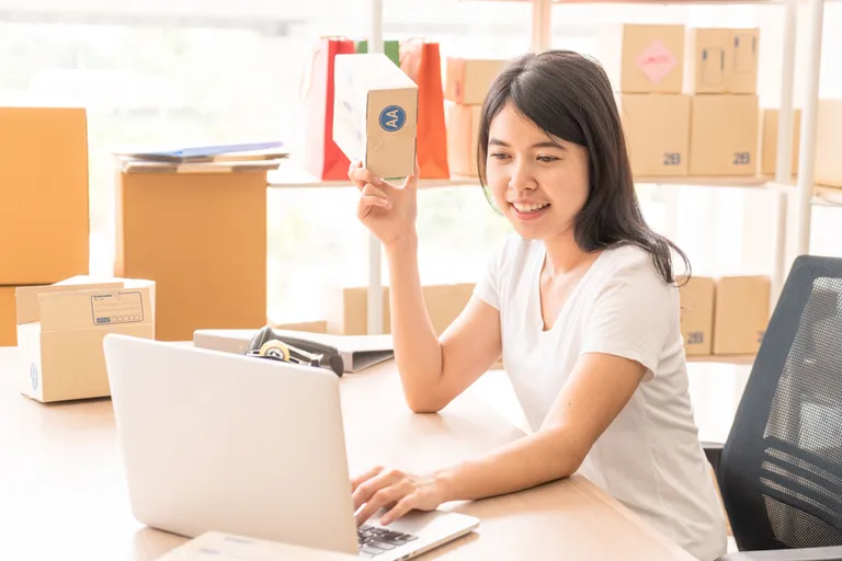 Empreendedora organizando pedidos e produtos enquanto aprende como montar um negócio online estruturado