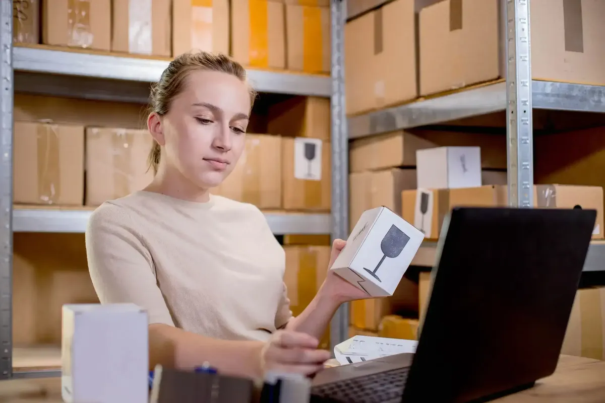 Funcionária conferindo produtos e atualizando dados no app de controle de estoque