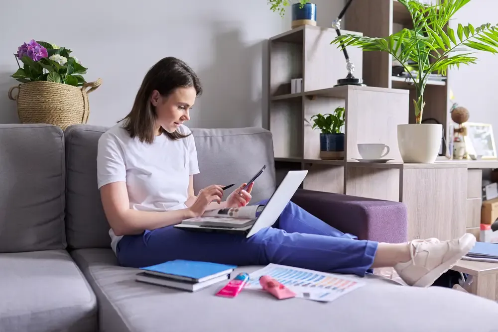 Vendedora revisando itens no catálogo de produtos digital pelo celular e laptop