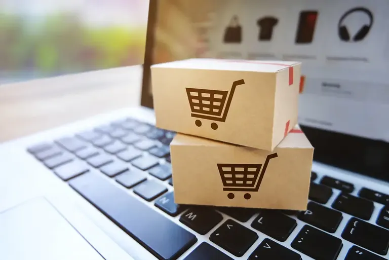 Caixas de entrega sobre o teclado representando vendas feitas por catálogo digital
