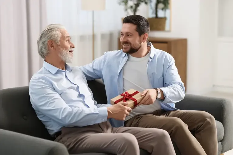 Momento de filho presenteando o pai com caixa de presente no Dia dos Pais