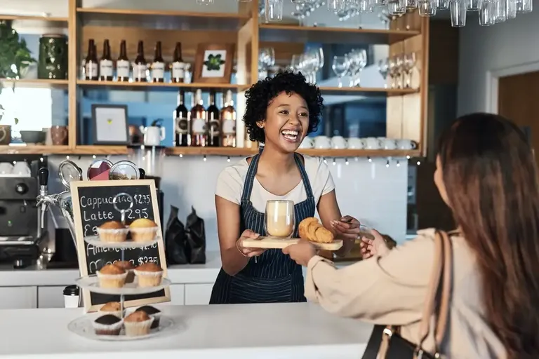 Funcionária servindo cliente com simpatia, exemplificando um pós-venda acolhedor.