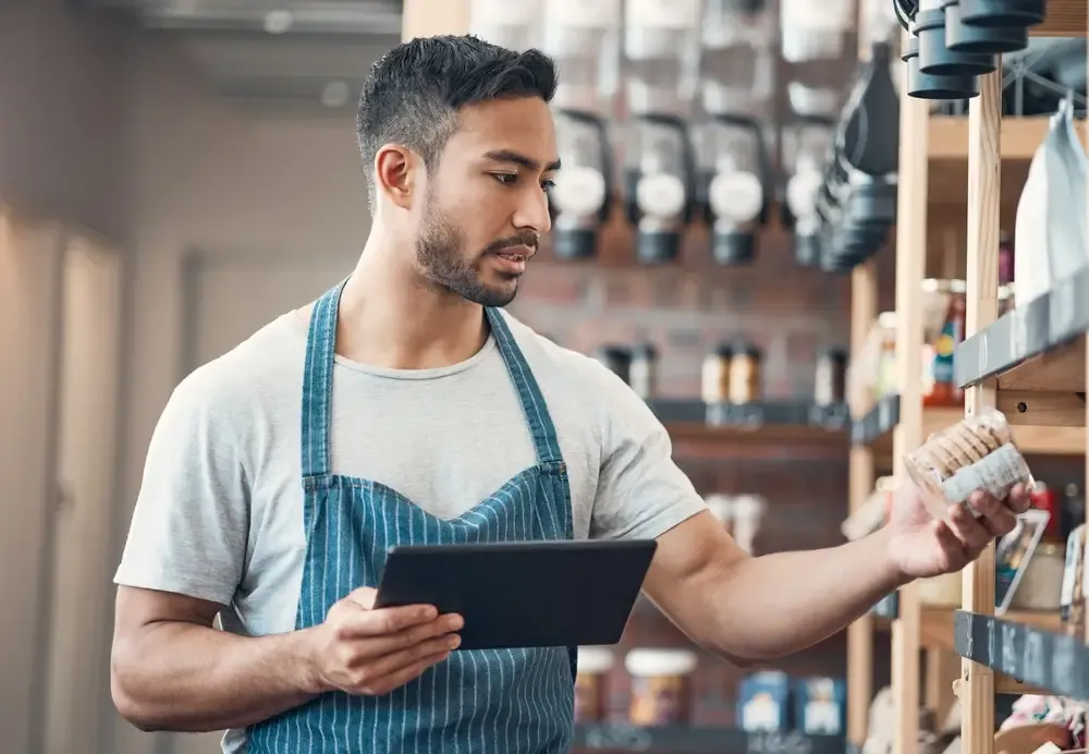 Vendedor analisando itens e registrando informações de estoque no tablet