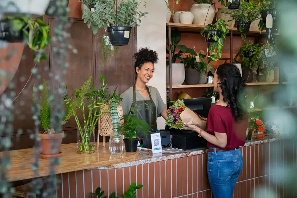 Loja de flores atendendo cliente simbolizando práticas seguras ao vender fiado